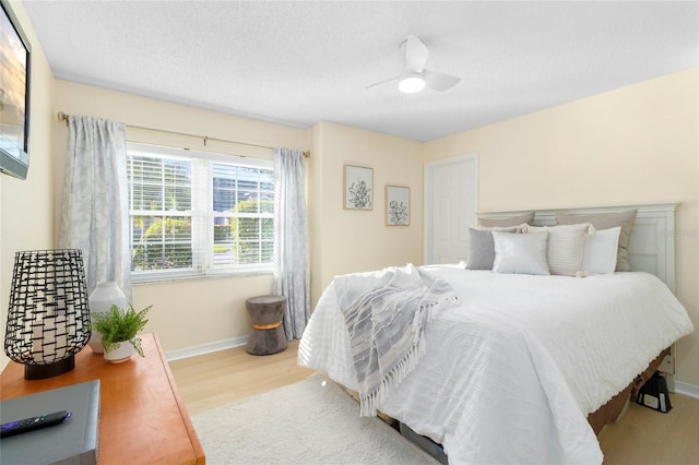 bedroom featuring a textured ceiling, light hardwood / wood-style flooring, and ceiling fan