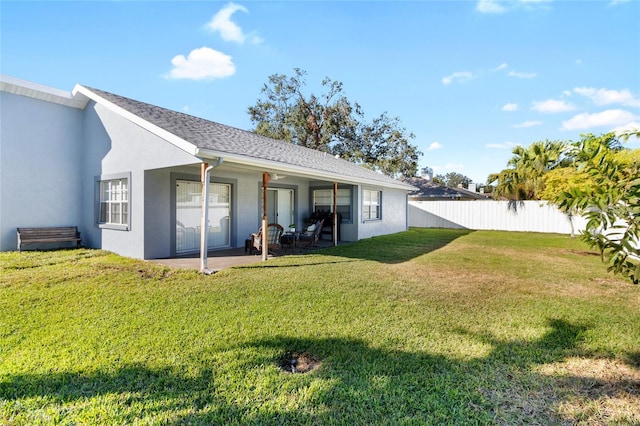 rear view of property featuring a yard and a patio area