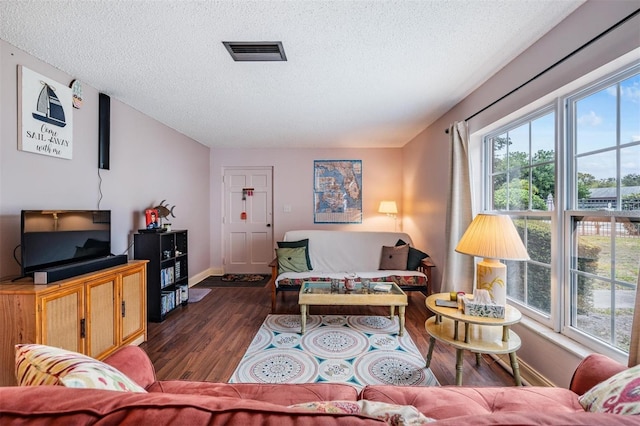 living room with dark hardwood / wood-style floors and a textured ceiling