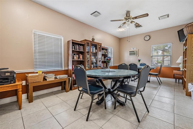 tiled dining area with ceiling fan and a wall unit AC