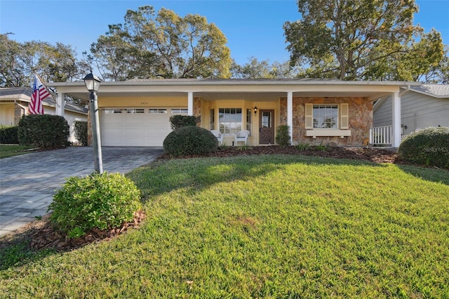 ranch-style home with covered porch, a garage, and a front lawn