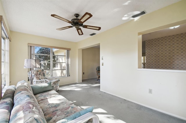 unfurnished living room featuring a textured ceiling, ceiling fan, and light carpet