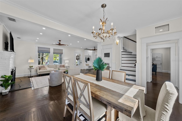 dining area with crown molding, a fireplace, dark parquet floors, and ceiling fan with notable chandelier