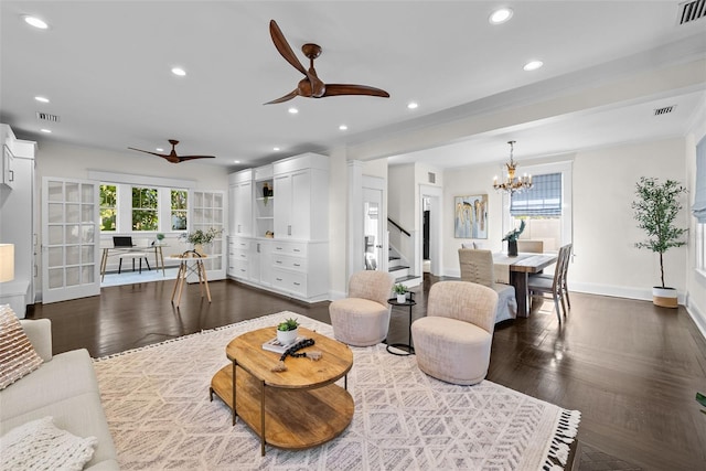 living room with ceiling fan with notable chandelier, dark hardwood / wood-style floors, and ornamental molding