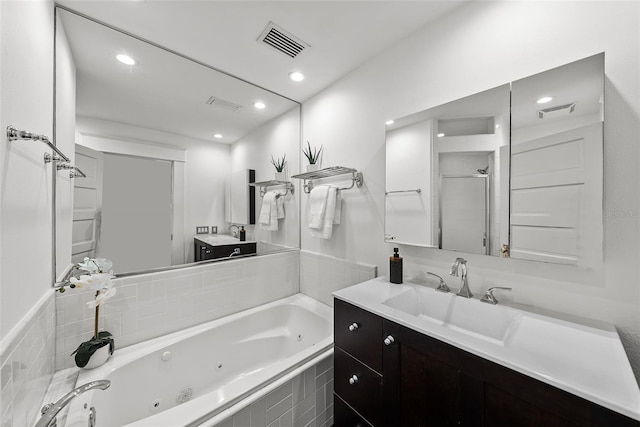 bathroom featuring vanity and independent shower and bath