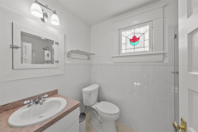 bathroom featuring tile patterned floors, vanity, toilet, and tile walls