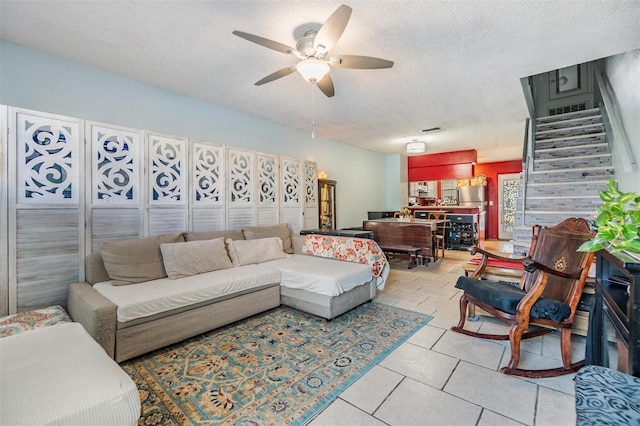 living room featuring a textured ceiling and ceiling fan