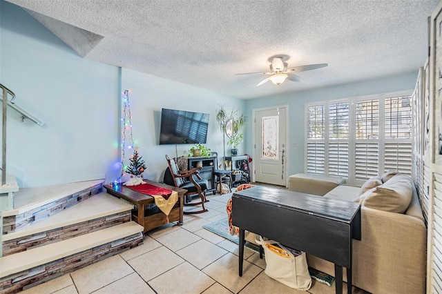 tiled living room featuring ceiling fan and a textured ceiling