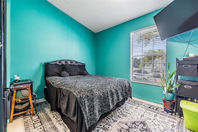 bedroom featuring a textured ceiling and lofted ceiling