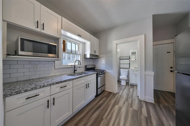 kitchen with dark wood-type flooring, sink, white cabinets, and stainless steel appliances