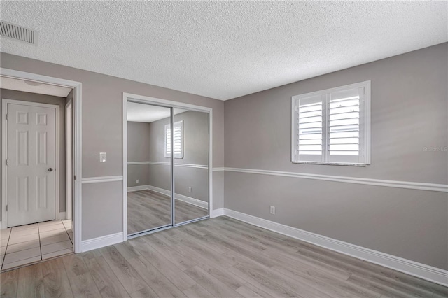 4915 Bay St NE Unit 123, Saint Petersburg, FL 33703 - unfurnished bedroom featuring light hardwood / wood-style floors, multiple windows, and a closet