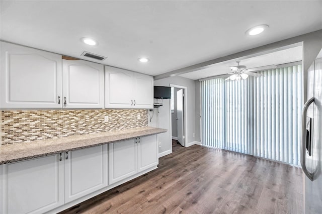4915 Bay St NE Unit 123, Saint Petersburg, FL 33703 - kitchen featuring light stone countertops, dark hardwood / wood-style flooring, tasteful backsplash, ceiling fan, and white cabinets