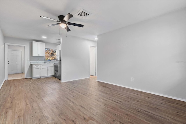 unfurnished living room with light hardwood / wood-style flooring and ceiling fan