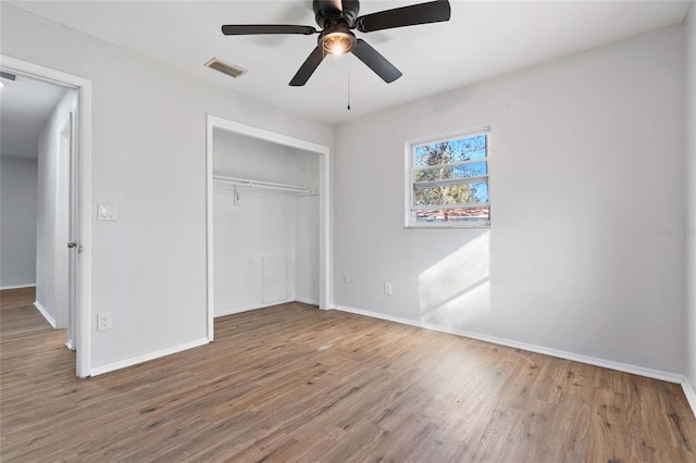 unfurnished bedroom featuring a closet, hardwood / wood-style flooring, and ceiling fan