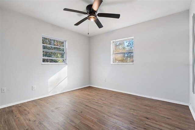 empty room with dark hardwood / wood-style floors and ceiling fan