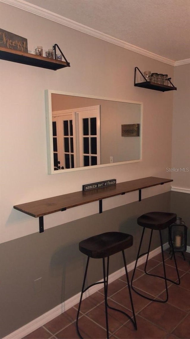 tiled dining room featuring crown molding