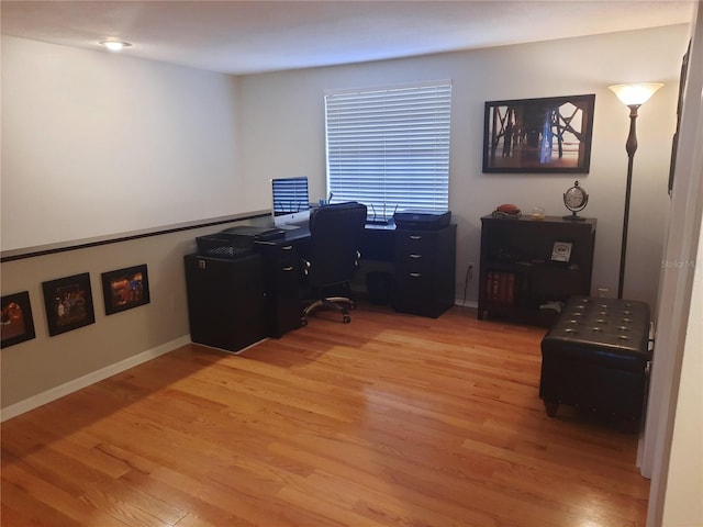 home office with light hardwood / wood-style flooring