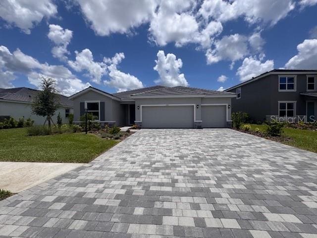 4315 Pullet Ct, Lakewood Ranch, FL 34211 - single story home with decorative driveway, a garage, a front lawn, and stucco siding