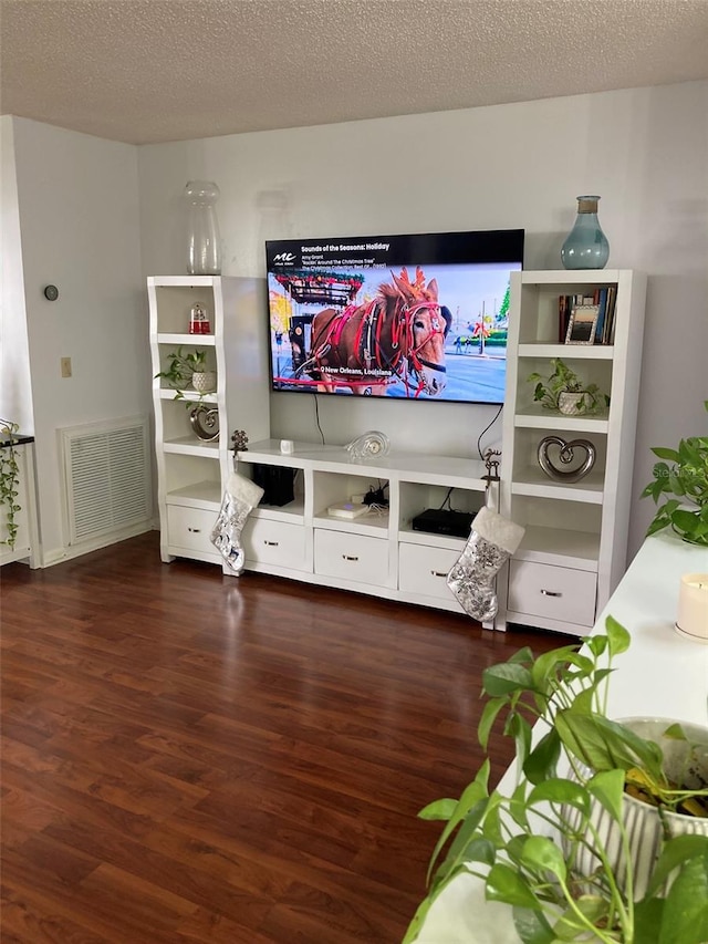 living room featuring dark wood-type flooring and a textured ceiling