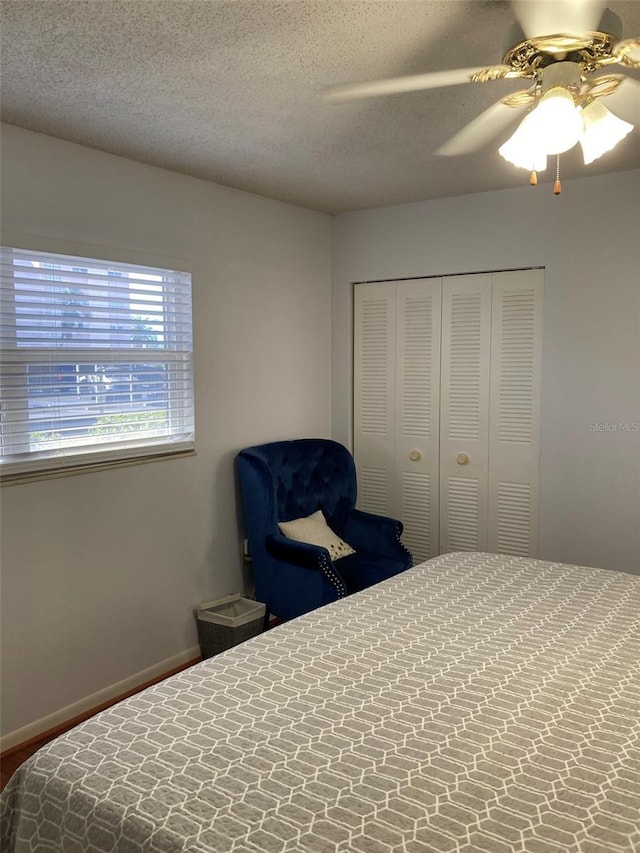 bedroom featuring ceiling fan, a closet, and a textured ceiling