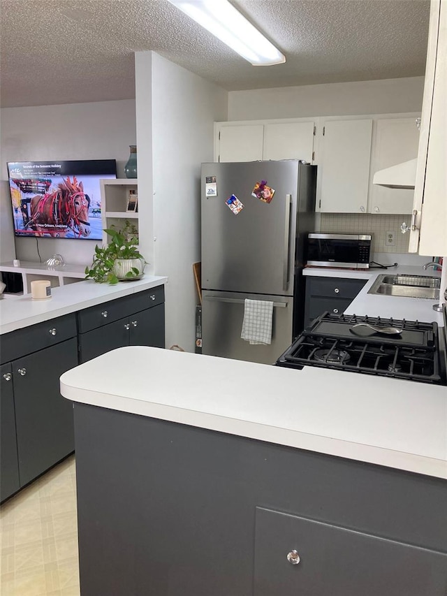 kitchen featuring white cabinetry, appliances with stainless steel finishes, sink, and a textured ceiling