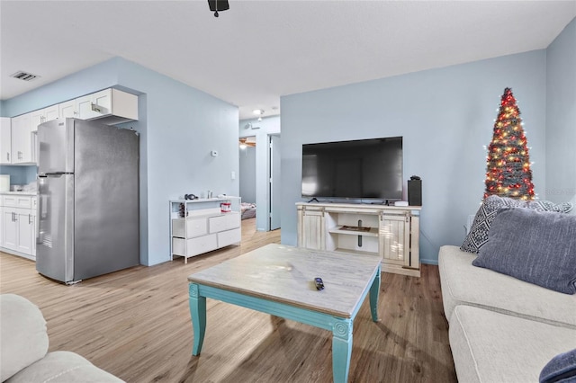 living room with ceiling fan and light hardwood / wood-style floors