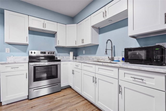 kitchen with white cabinets, electric stove, and sink