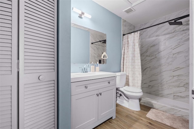 bathroom with hardwood / wood-style flooring, vanity, toilet, and walk in shower