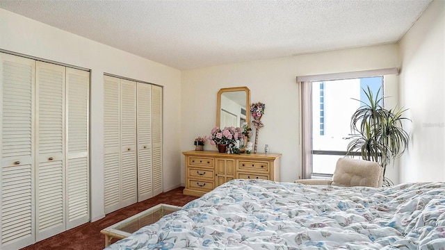 carpeted bedroom featuring a textured ceiling and two closets