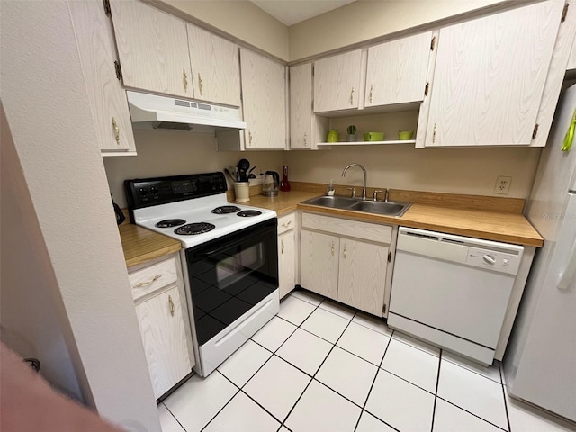 kitchen featuring sink, light tile patterned floors, and white appliances