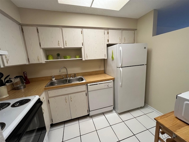 kitchen featuring light tile patterned flooring, white appliances, and sink