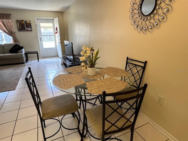 dining area featuring light tile patterned flooring and a textured ceiling