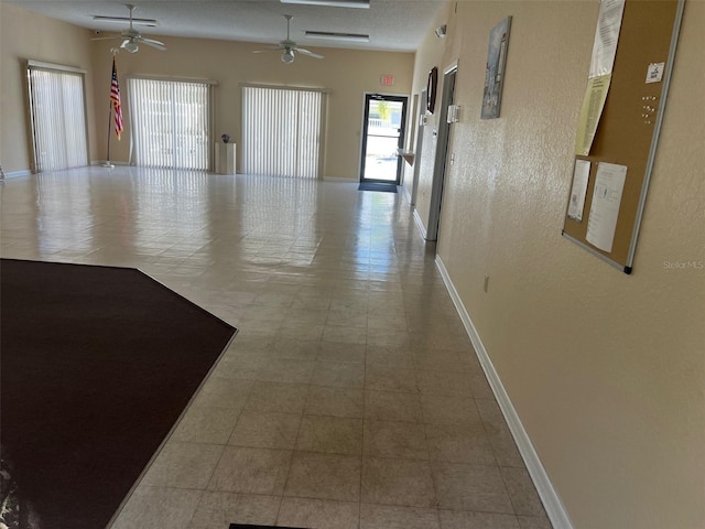 hall featuring light tile patterned floors and a textured ceiling