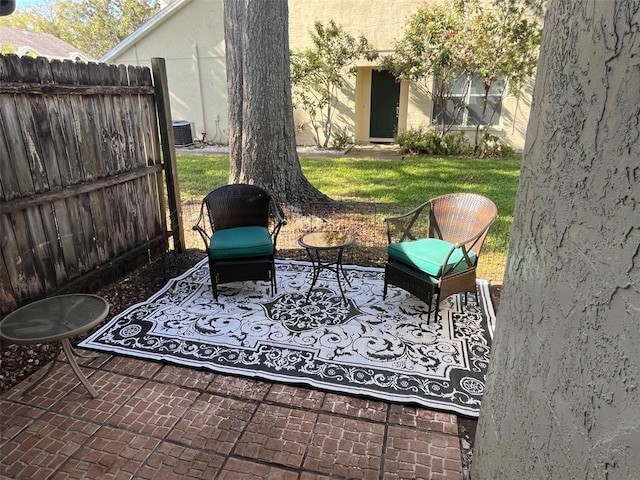 view of patio with central AC and fence