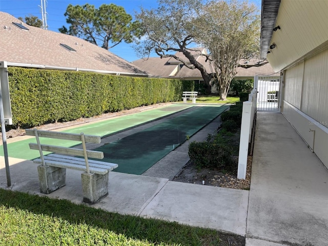 view of pool featuring a gate and shuffleboard