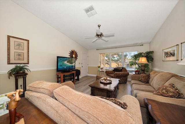 living room featuring ceiling fan, light hardwood / wood-style flooring, and vaulted ceiling