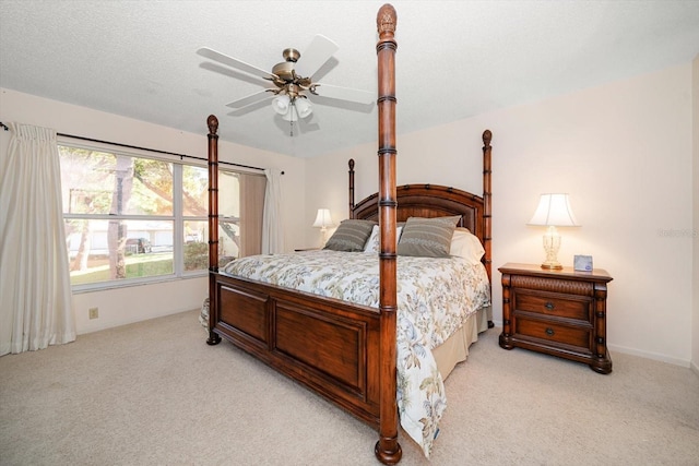 carpeted bedroom featuring a textured ceiling and ceiling fan