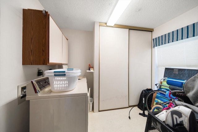 clothes washing area featuring cabinets, light carpet, a textured ceiling, and separate washer and dryer