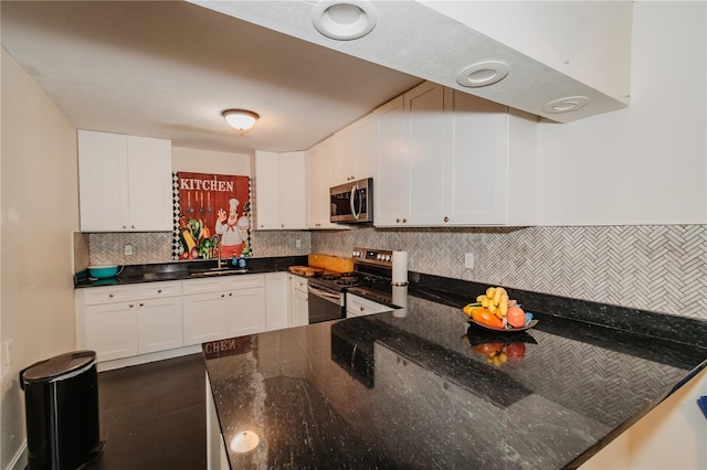 kitchen with white cabinets, dark stone counters, and appliances with stainless steel finishes