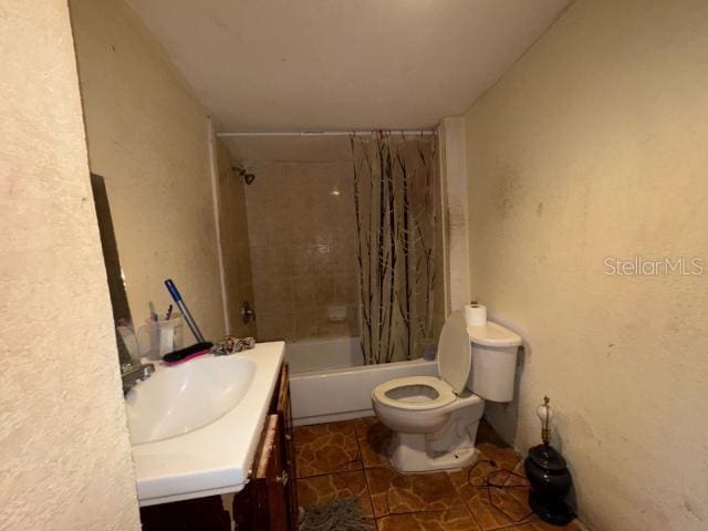 full bathroom with shower / tub combo, vanity, toilet, and tile patterned floors