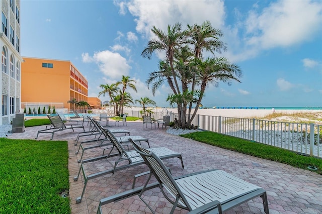 view of patio / terrace with a water view and a beach view