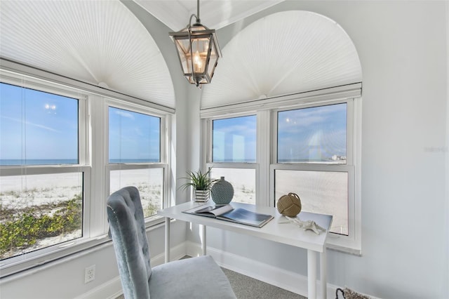 office featuring carpet floors, a water view, and a notable chandelier