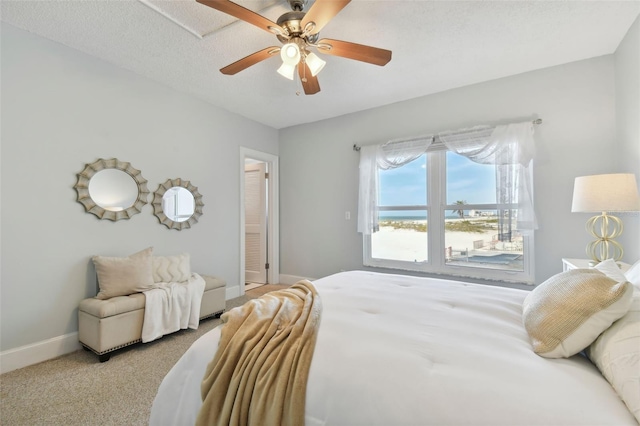 bedroom with a textured ceiling, ceiling fan, and light carpet