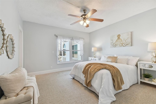 carpeted bedroom featuring ceiling fan and a textured ceiling