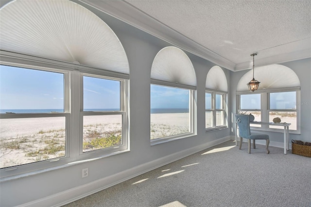 interior space featuring ornamental molding, a water view, a textured ceiling, and baseboards