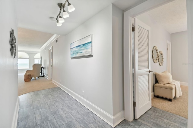 hall featuring carpet floors and baseboards