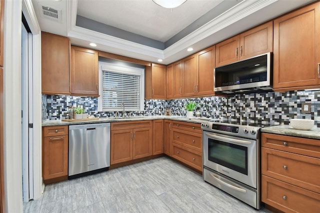 kitchen featuring appliances with stainless steel finishes, decorative backsplash, a sink, and visible vents