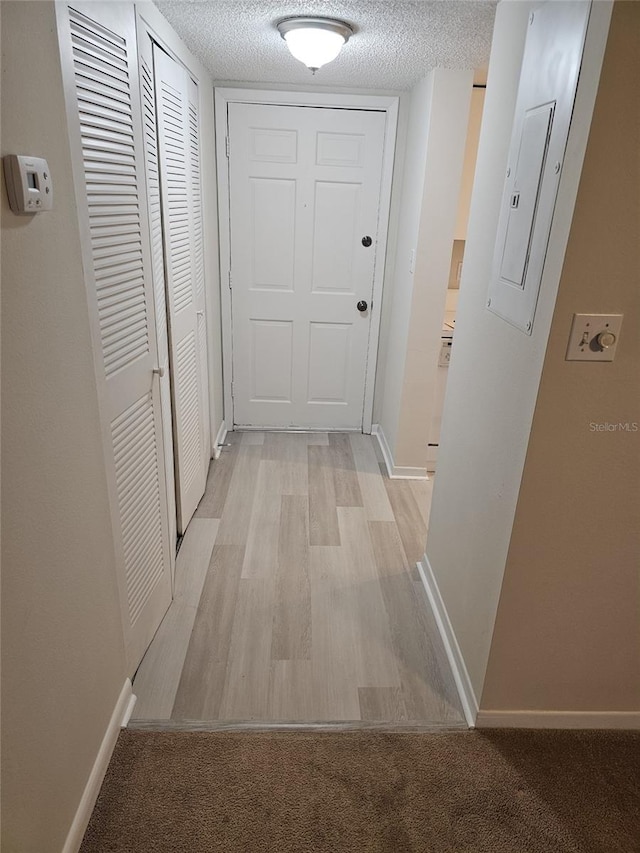 203 47th Avenue Dr W Unit 167, Bradenton, FL 34207 - hall featuring a textured ceiling, baseboards, electric panel, and light wood-style flooring