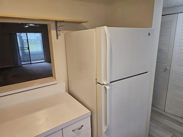 kitchen with white cabinets, ceiling fan, light hardwood / wood-style flooring, and white fridge