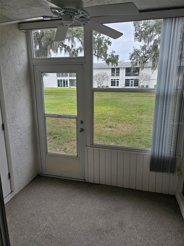 doorway to outside with carpet flooring, a wealth of natural light, and ceiling fan